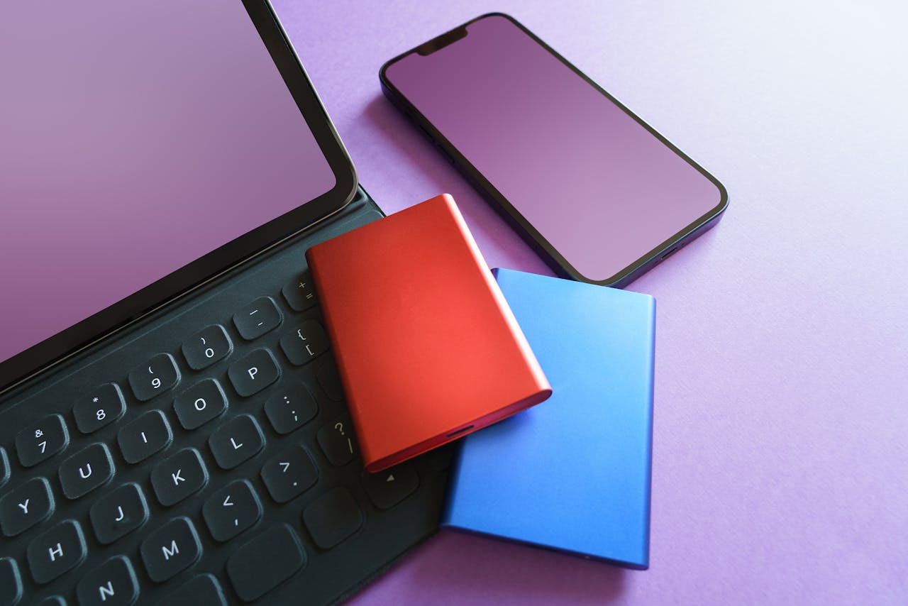 about-02 Colorful gadgets including a smartphone, tablet, and SSD on a purple background, ideal for tech-themed projects.